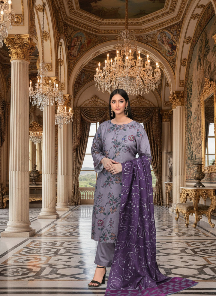 Woman in a gray floral dress with a purple dupatta standing in front of a decorative wall.